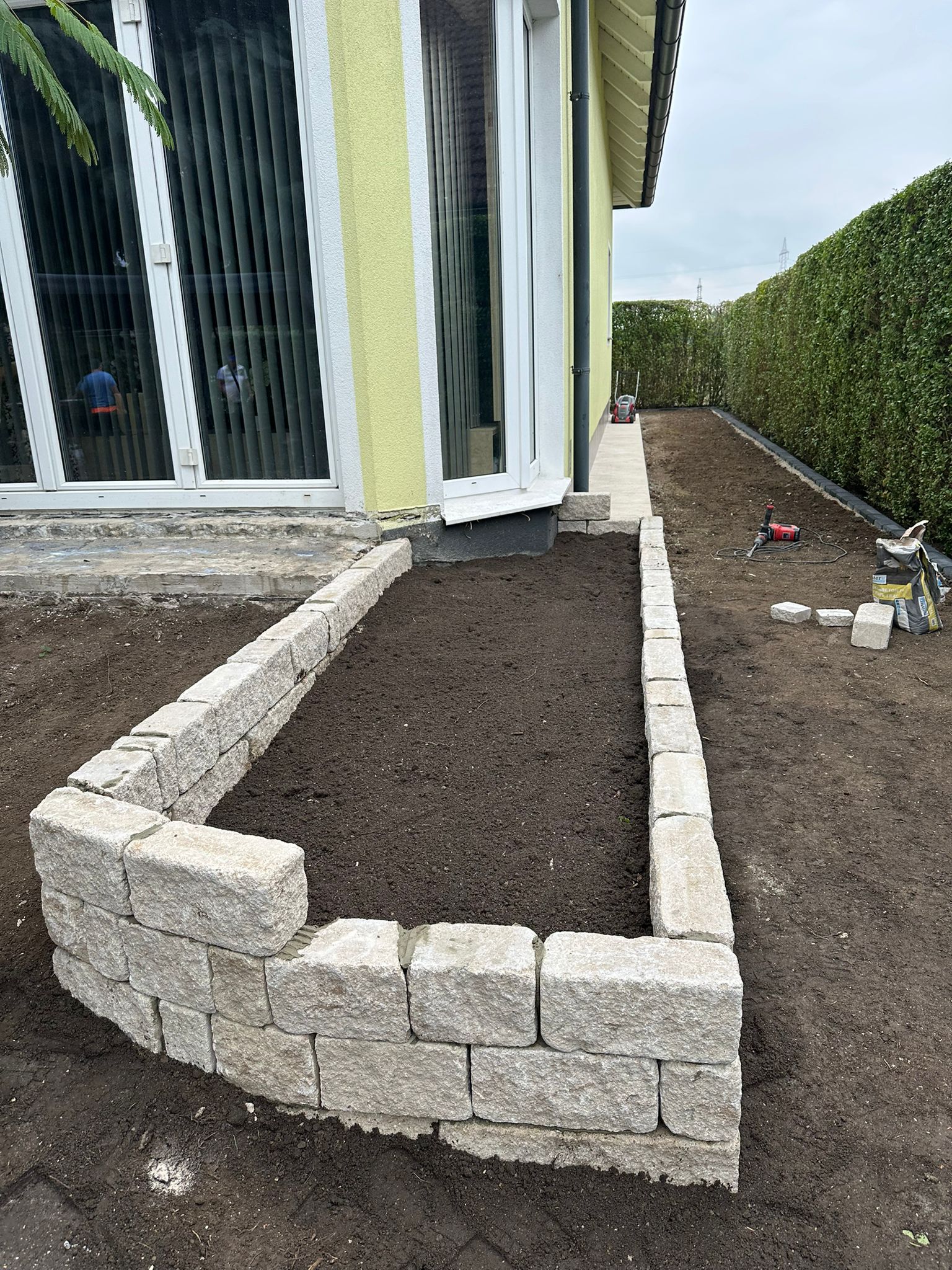 Natursteinmauer und Beeteinfassung mit Hecke