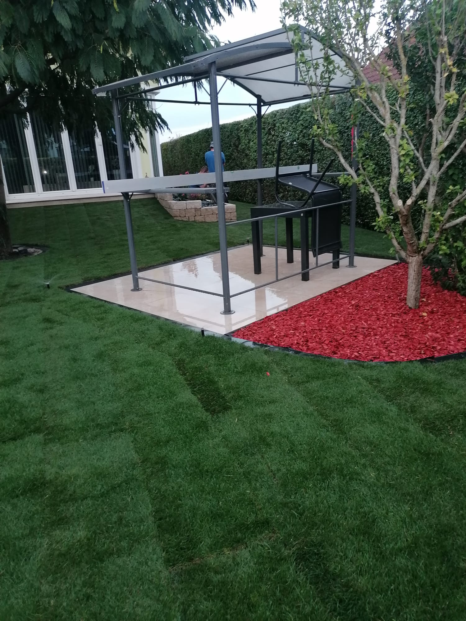 Sauberer Rasen mit Pavillon und roter Mulchdekoration