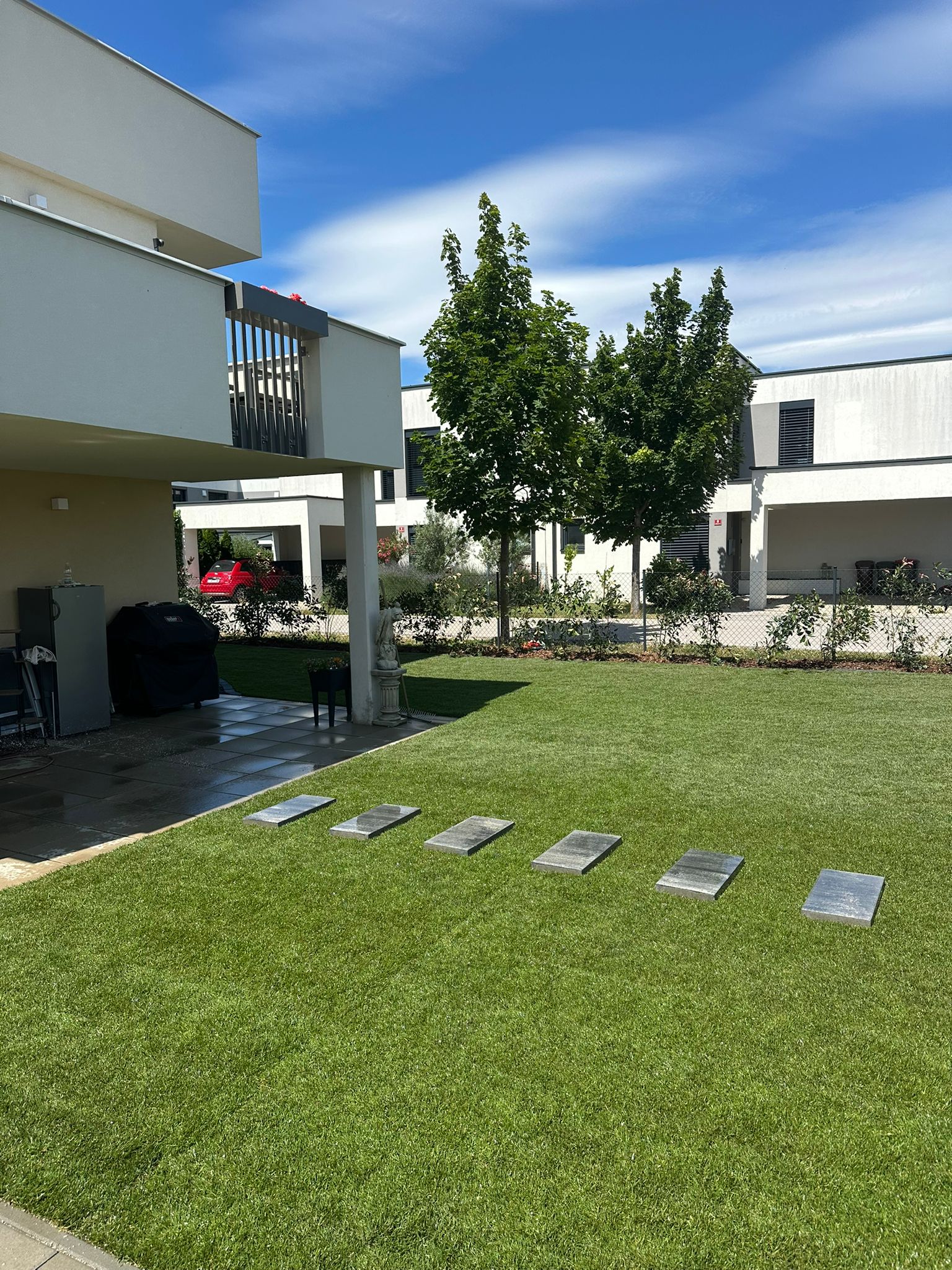 Moderne Gartengestaltung mit perfektem Rasen und Trittsteinpfad